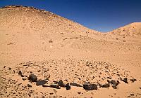 Monument  Mouments en pierres sèches avant les dunes d'Agholibi. Un grand tumulus discoïde associé à une plate-forme empierrée.