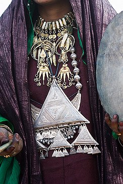 Bijoux Les femmes portent de nombreux bijoux. Au cou, la cha'riya d'argent trempée dans de l'or, sur la poitrine, le volumineux takardé composé de triangles.