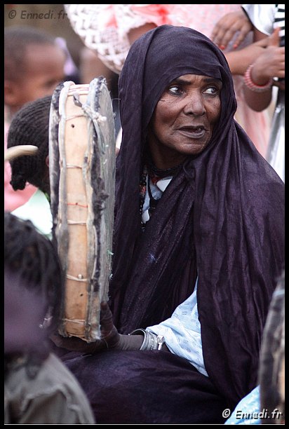 tazrouk-13.jpg - Les chants sont accompagnés par des percussions. Le "ganga" est un tambour à deux peaux étirées autour d'un cadre en bois circulaire. Les femmes le tienne d'une main et le frappe par l'autre à l'aide d'une baguette en bois dénommée "tagourbat".